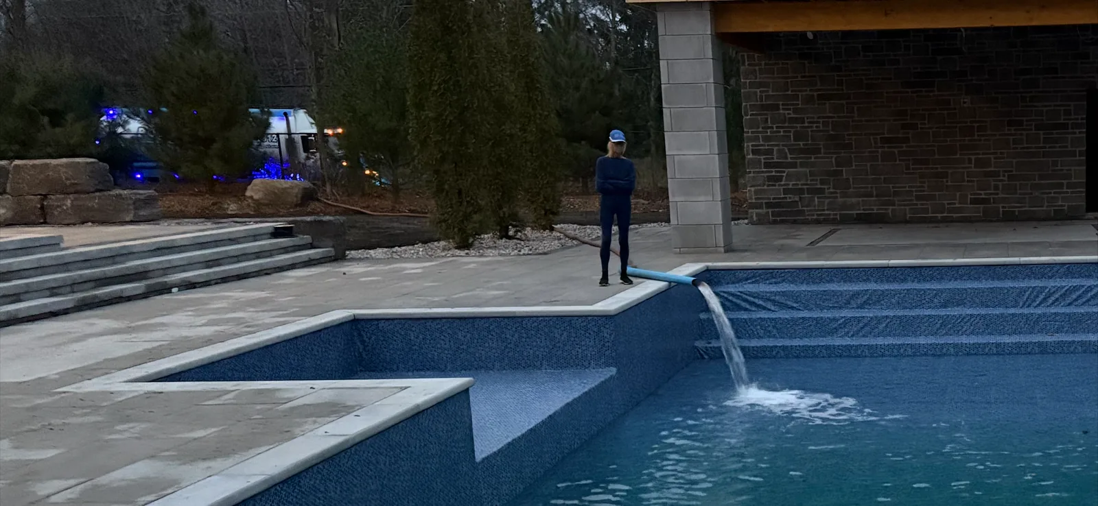 Pool Side Water Services crew member filling a brand-new pool and spa in Ottawa